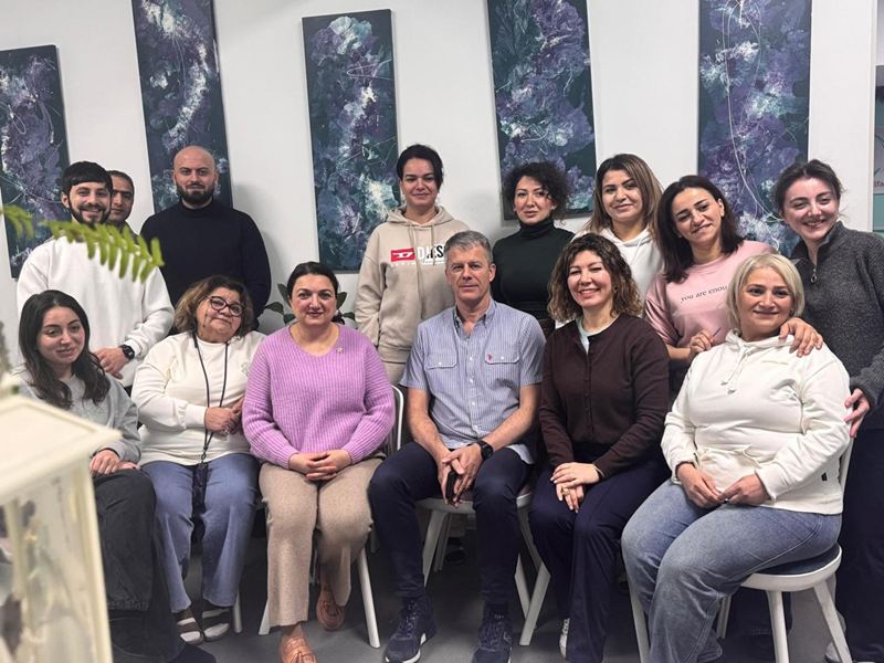 Tələbələr və dəvətli müəllim ELF Center-in rəsm əsərləri olan zalında oturmuş vəziyyətdə.