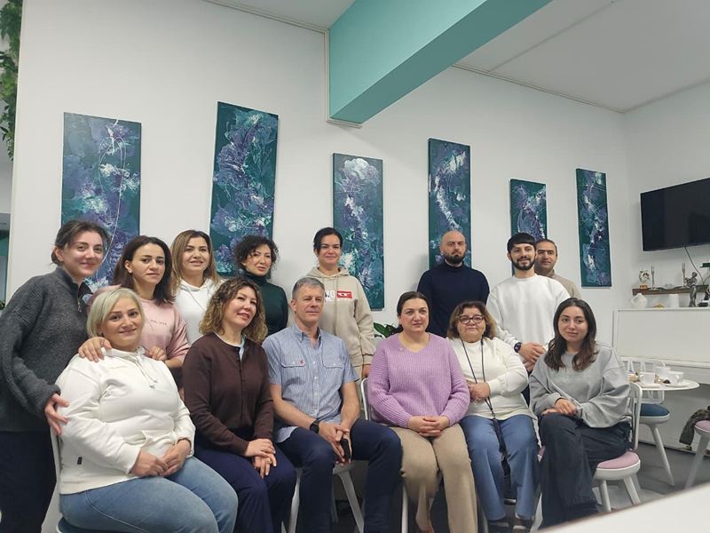 Tələbələr və müəllim ELF Center-in rəsm əsərləri ilə bəzədilmiş zalında qrup şəklində.