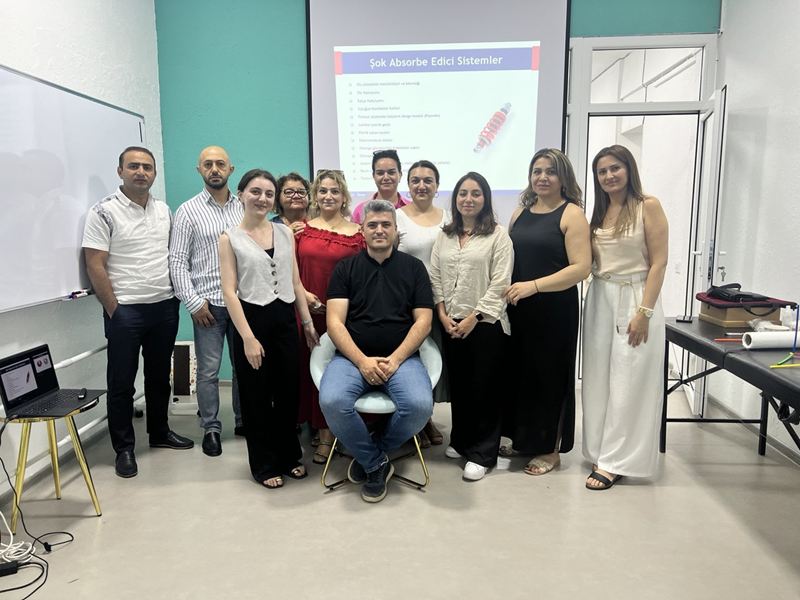 Klinik anatomiya və biomexanika dərsi: ekranda biomexanikaya dair slayd, önündə tələbələr və müəllim.